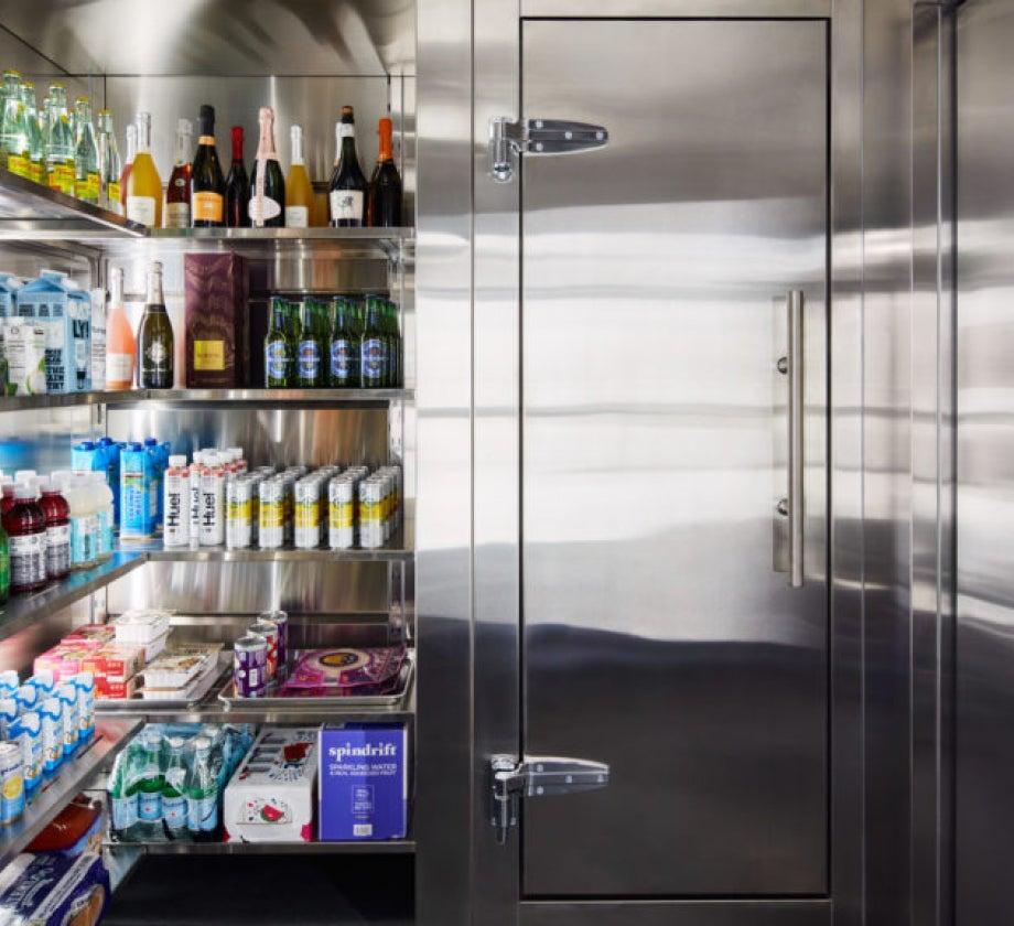 Interior of the Qoldfusion Dual-Temp refrigerator with various beverages and food items.